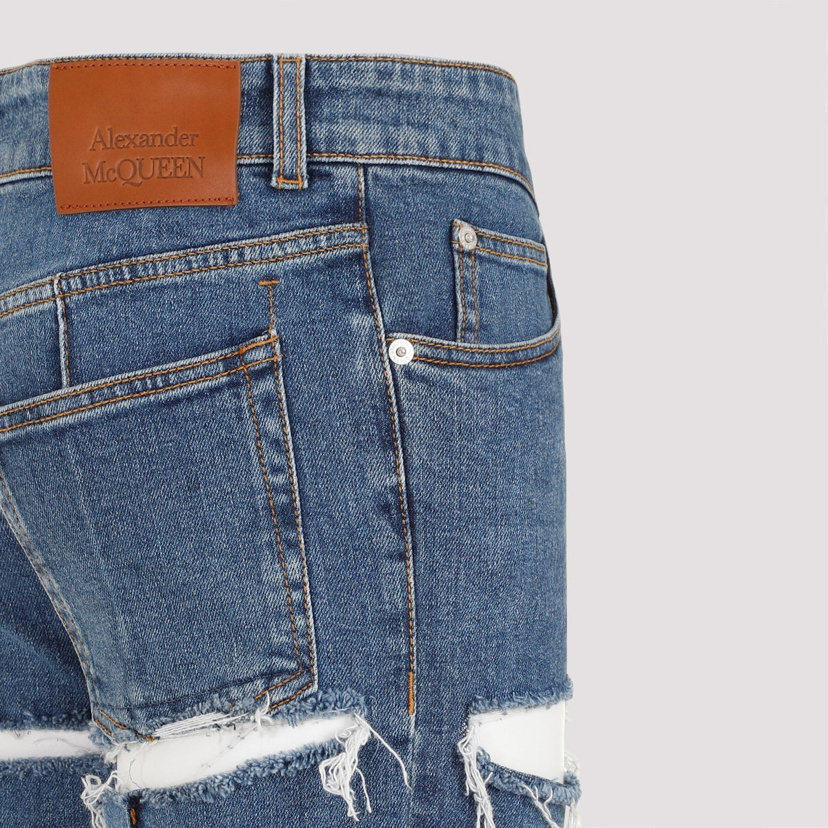Close-up of Alexander McQueen pants hardware and fine stitching