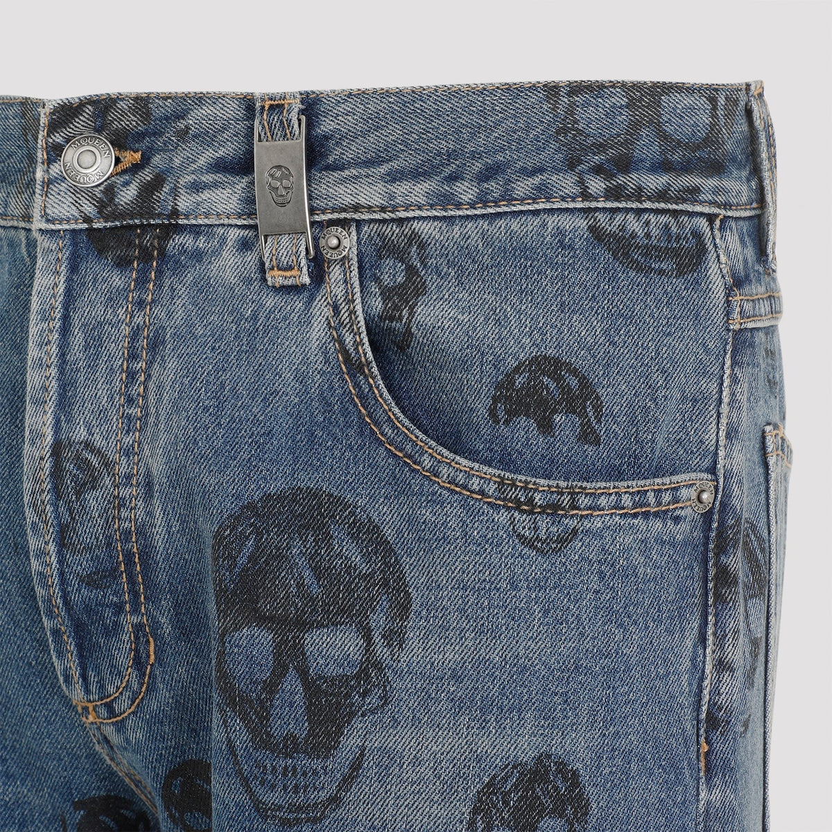 Close-up of Alexander McQueen pants hardware and fine stitching