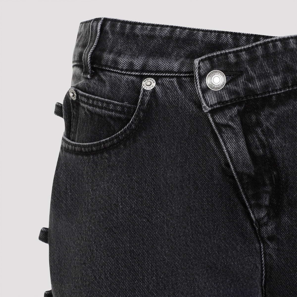 Close-up of Alexander McQueen pants hardware and fine stitching