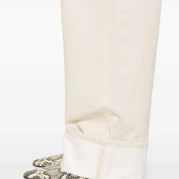 Close-up of Bottega Veneta pants hardware and fine stitching
