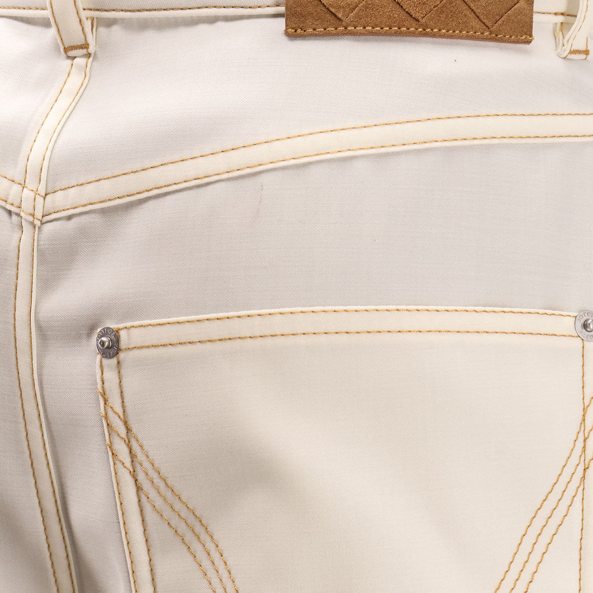 Close-up of Bottega Veneta pants hardware and fine stitching