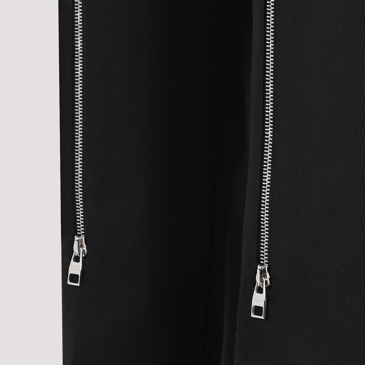 Close-up of Alexander McQueen pants hardware and fine stitching