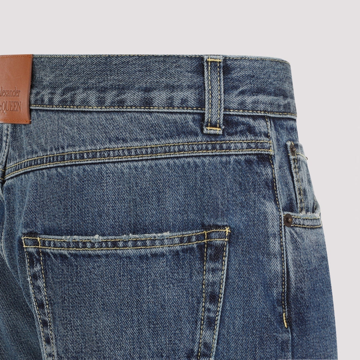 Close-up of Alexander McQueen pants hardware and fine stitching