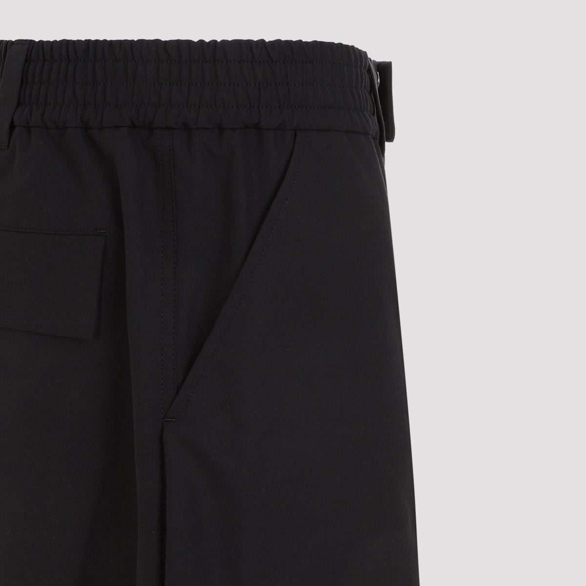 Close-up of Alexander McQueen pants hardware and fine stitching