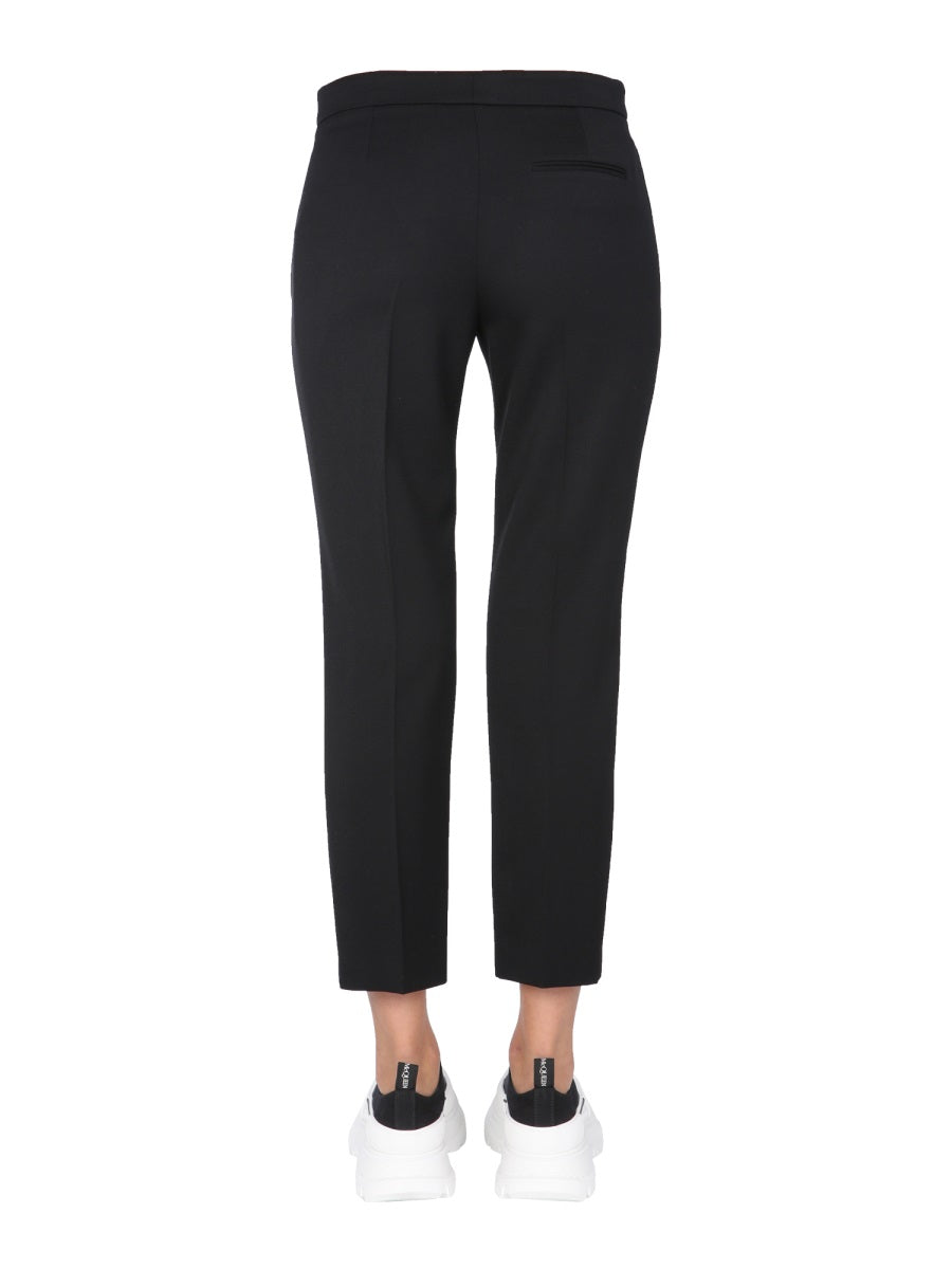 Close-up of Alexander McQueen pants hardware and fine stitching