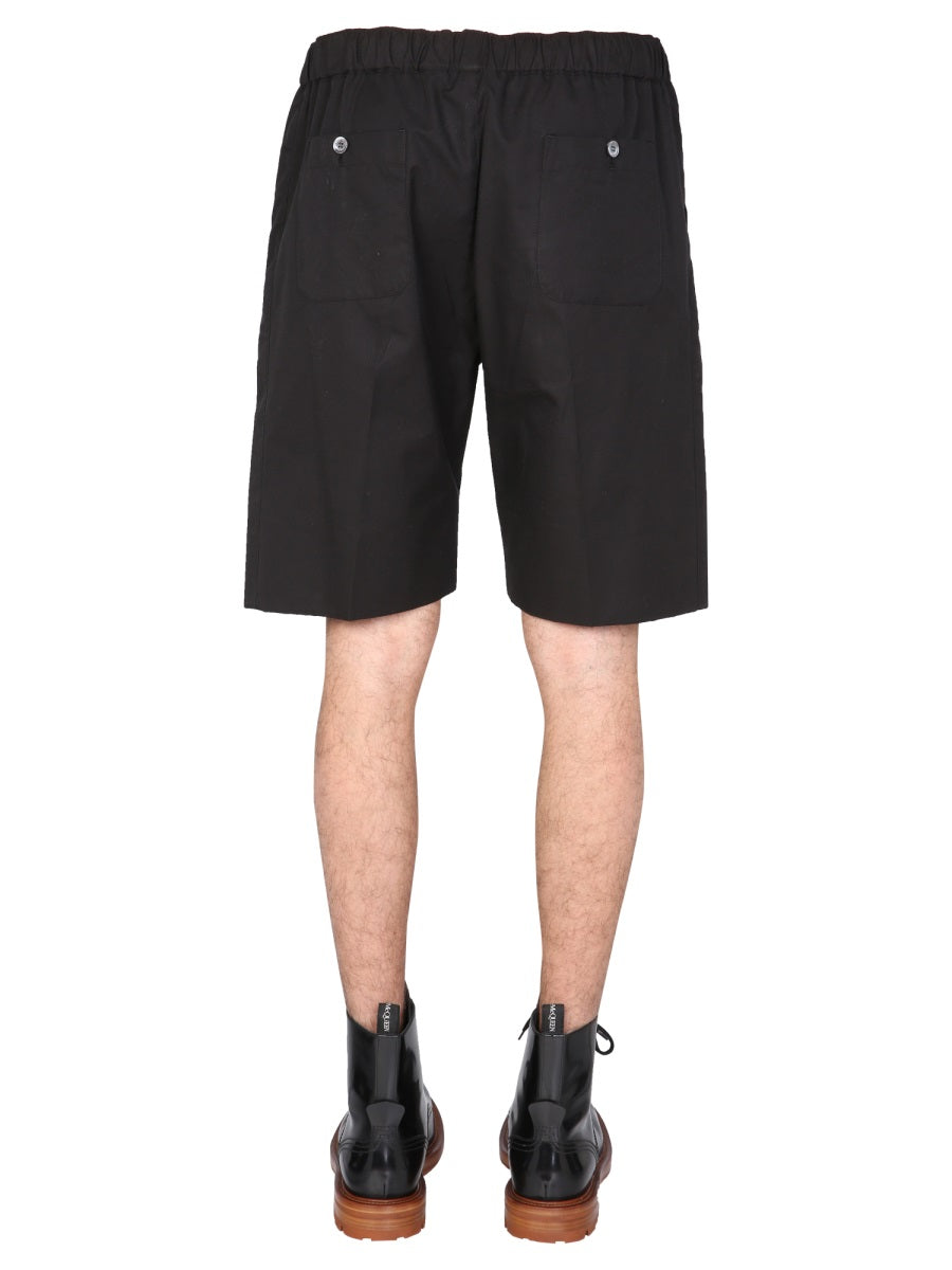 Close-up of Alexander McQueen pants hardware and fine stitching