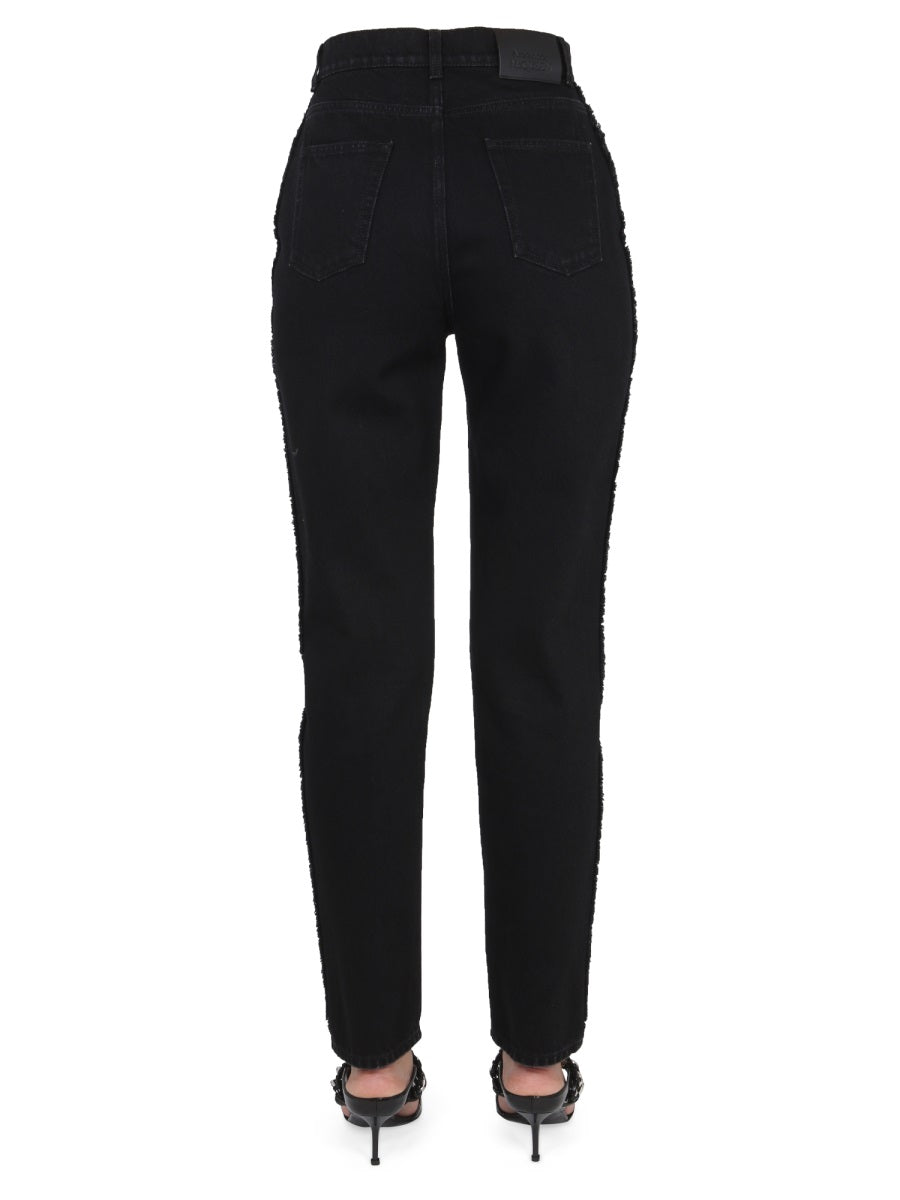 Close-up of Alexander McQueen pants hardware and fine stitching