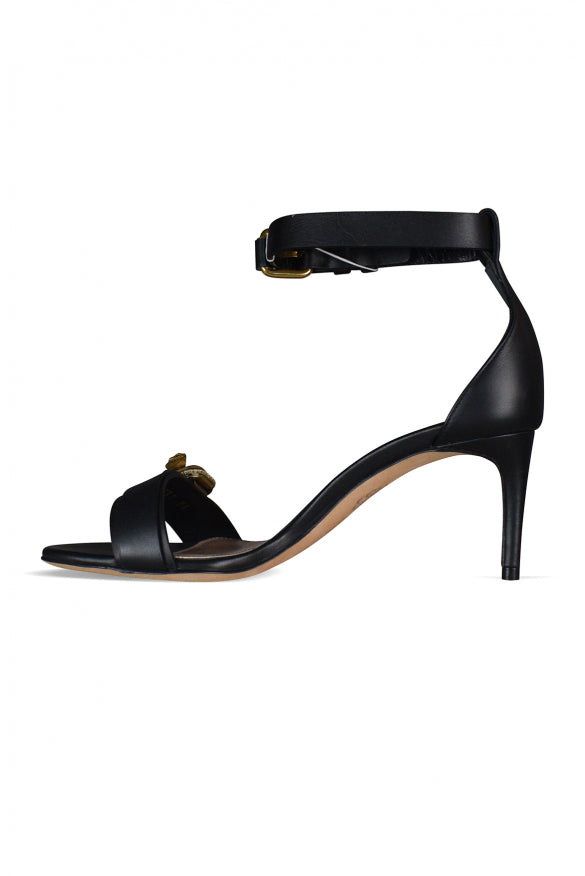 Close-up of Alexander McQueen sandals hardware and fine stitching