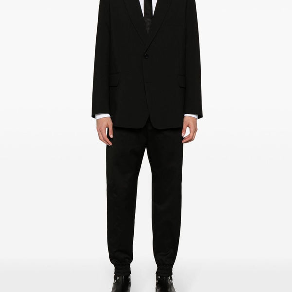 Close-up of Alexander McQueen pants hardware and fine stitching